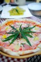 Pizza eine Mischung aus Cannabisblättern, entwickelt für Gesundheitsliebhaber in einer neuen, lizenzierten und legalen Form. garantierte Sicherheit, helfen, Angst zu lindern, Traurigkeit zu reduzieren. Konzept Cannabis für die Gesundheit. foto