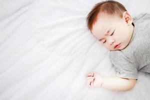 schlafendes süßes babymädchen tagsüber auf dem bett foto