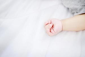 Nahaufnahmeporträt der Babyhand und eines schlafenden neugeborenen Babys foto