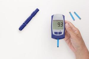 Glukometer in der Hand mit 9,3 mmol pro Liter glykämischem Index auf dem Display foto