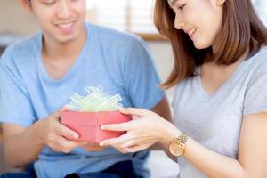 schönes junges asiatisches paar in der liebe überraschungsgeschenkbox im schlafzimmer zu hause, familienjubiläum mit genießen und romantisch zusammen ehefrau und ehemann mit beziehung, feiern valentinstag konzept. foto