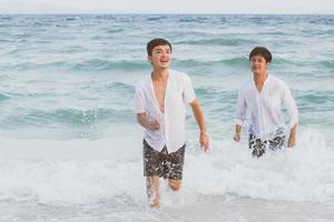 homosexuelles porträt junges asiatisches paar, das im sommer fröhlich zusammen am strand läuft, asien homosexueller tourismus für die freizeit und entspannen sie sich mit glück im urlaub auf meer, lgbt-rechtskonzept. foto