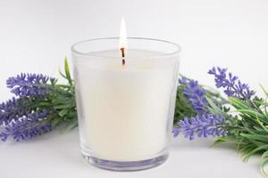 Kerze im Glas auf weißem Hintergrund mit Lavendel, Produktmodell foto