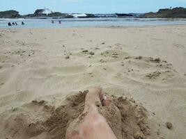 Füße und Beine im Sand am Strand von Isabela Puerto Rico vergraben foto