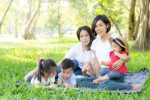 schönes junges asiatisches elternfamilienporträt picknick im park, kind oder kinder und mutter lieben glücklich und fröhlich zusammen im sommer im garten, lifestyle-konzept. foto