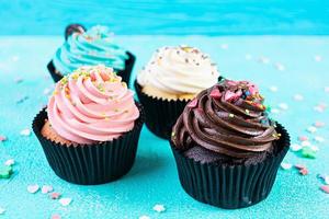 leckere bunte Cupcakes isoliert auf blauem Hintergrund. leckerer Kuchen foto