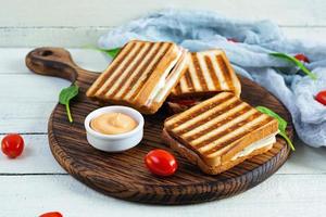 Club-Sandwich mit Schinken, Tomate, Käse und Spinat. gegrillte panini foto