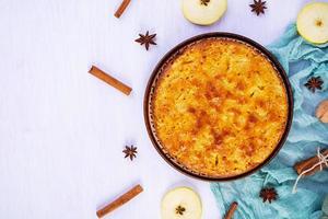 köstlicher hausgemachter apfelkuchen auf rosa hintergrund. Apfelkuchen mit Zutaten, Äpfeln und Zimt foto