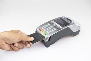 Schließen Sie die Hand des Mannes mit der Kreditkarte, die den Kreditkartencode eingibt, um den Online-Einkauf auf dem weißen Tischboden zu bezahlen foto