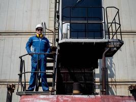 vorarbeiter ingenieur männlich helm helm weiß blau sicherheit stehend blick kamera arbeit job karriere einfuhr export technik gabelstapler container versand lieferung logistik güterverkehr kaufmännisch kontrolle foto