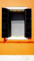 fenster in burano an orangefarbener wand foto