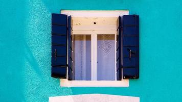 blaues fenster in burano an blauer ccolor-wand foto