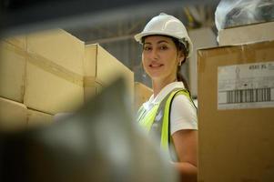 Lagerarbeiterin beim Zählen von Artikeln in einem Industrielager im Zwischengeschoss der Fabrik. das ist ein Lager für kleine und leichte elektronische Teile. foto