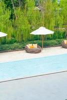 Außenterrassenstuhl mit Kissen und Sonnenschirm rund um den Pool foto