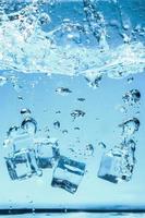 abstraktes Hintergrundbild von Eiswürfeln im blauen Wasser. foto