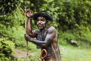 Porträt eines Dani-Stammmannes, der Koteka trägt, traditionelle Kleidung von Papua. Männer des Dani-Stammes, die bereit sind, Tierbeute im Dschungel zu jagen. foto