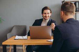 Personalvermittler während eines Vorstellungsgesprächs im Büro mit einem männlichen Kandidaten foto