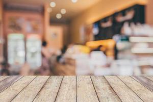 Holztischplatte mit abstraktem Unschärfe-Café-Hintergrund foto