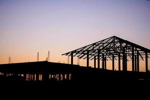 Silhouette Hausbau auf Baustelle Sonnenuntergang Hintergrund foto