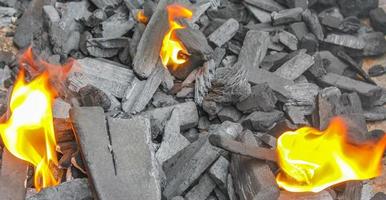 Grill-Lagerfeuer vorbereiten und Holz mit orangefarbenen Flammen verbrennen. foto