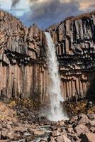 mächtige kaskaden des svartifoss-wasserfalls inmitten von basaltsäulen im nationalpark foto