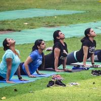 neu delhi, indien, 18. juni 2022 - gruppen-yoga-übungskurs für menschen unterschiedlichen alters im lodhi garden park. internationaler tag des yoga, große gruppe von erwachsenen, die draußen im park einen yogakurs besuchen foto