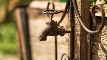 Wasserhahn als Deko in alt mit Rost auf einem Holzbrett. foto