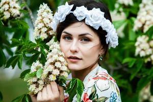 Frauenporträt mit einem Haar, das sich im Wind bewegt. porträt des jungen schönen russischen brünetten mädchens im sommergrünen park. Europäische weiße Frau im Kleid. foto