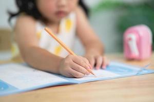 nahaufnahme hand süßes kleines kind verwendet holzfarbenmalerei mit bunten farben. asiatisches mädchen, das holzfarbzeichnungsfarbe verwendet. baby-künstleraktivitäts-lifestyle-konzept. foto