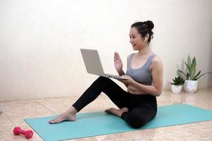 eine frau, die zu hause yoga-übungen macht foto