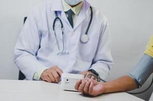 Arzt misst den Blutdruck eines älteren männlichen Patienten. foto
