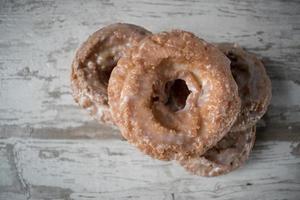 Stapel glasierter Donuts auf rustikalem Tisch foto