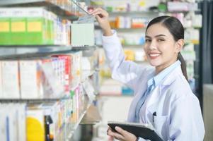 Porträt der Apothekerin mit Tablet in einer modernen Apotheke Drogerie. foto