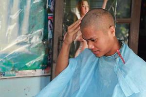 professioneller friseur rasiert den kopf des jungen mannes, um in seinem eigenen stil gut auszusehen. Sehen Sie sich das Haardetail aus der Nähe an.-2-4-2015-nakhon pathom thailand foto