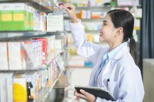 Porträt der Apothekerin mit Tablet in einer modernen Apotheke Drogerie. foto