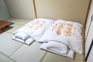 futon eine japanische gesteppte matratze, die auf dem boden tatami ausgerollt wird, um sie als bett zu verwenden., japanischer stil. foto