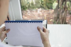 mann macht bericht mit kammbindemaschine - leute, die mit dem konzept stationärer werkzeuge arbeiten foto