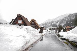 die dörfer shirakawago und gokayama gehören zu den unesco-welterbestätten japans. Bauernhaus im Dorf und Berg dahinter. foto