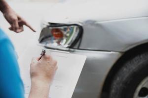 versicherungsagent, der während des autounfall-anspruchsverfahrens vor ort arbeitet - menschen- und autoversicherungsanspruchskonzept foto