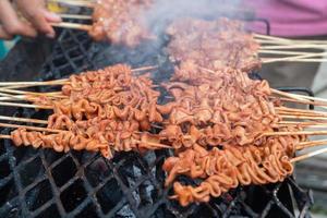 Selektiver Fokus auf Hähnchendarm-Satay, gegrillt über Holzkohle foto