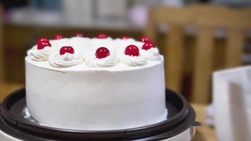 Weiße Sahnetorte mit rotem Geleeball-Topping - hausgemachtes Bäckereikonzept foto