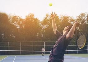 Tennismatch, bei dem ein dienender Spieler foto