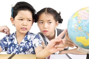 asiatische Kinder studieren den Globus auf weißem Hintergrund foto