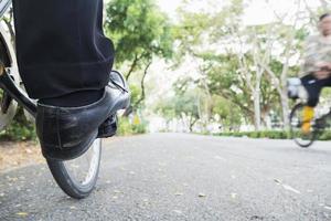 Student fährt Fahrrad auf einem grünen Campus foto