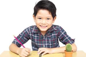 Ein Junge macht glücklich Hausaufgaben isoliert auf weißem Hintergrund foto