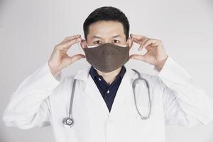asiatischer arzt trägt doppelschichtmasken zum schutz des covid-19-virus - arbeitskonzept für medizinische menschen foto