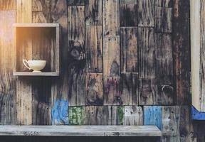 alter Holzwandhintergrund mit Regalen und alter Kaffeetasse foto