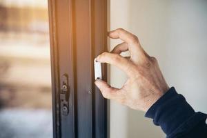 mann, der aluminiumrahmen mit gläsern und drahtgittertüren und fensterinstallationsarbeiten auf der baustelle durchführt foto