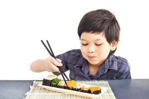 asiatischer schöner Junge isst Sushi isoliert auf weißem Hintergrund foto