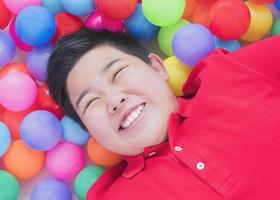 glückliches asiatisches kind mit bunten spielzeugbällen foto